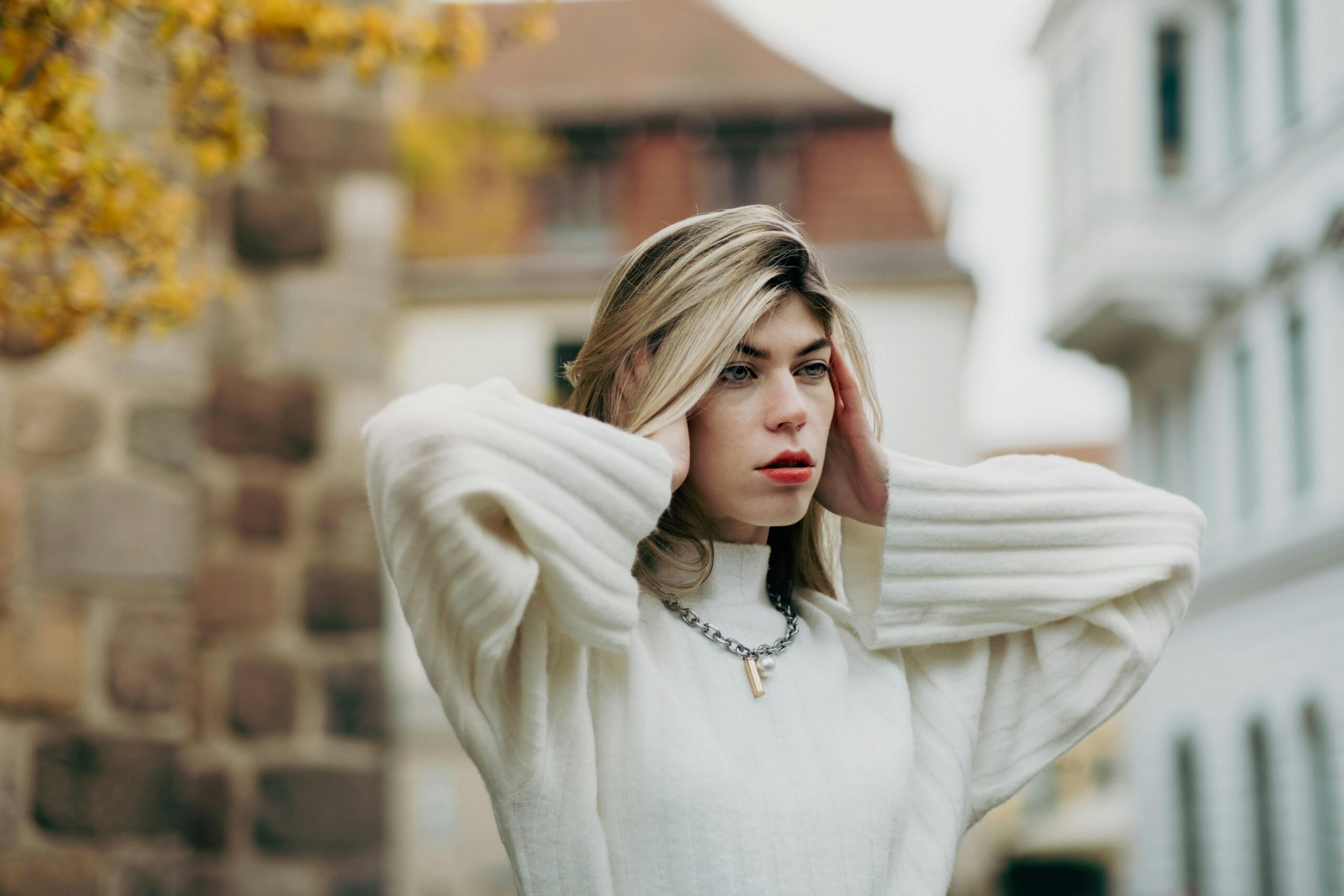 Kobieta z blond włosami zakrywająca uszy rękami