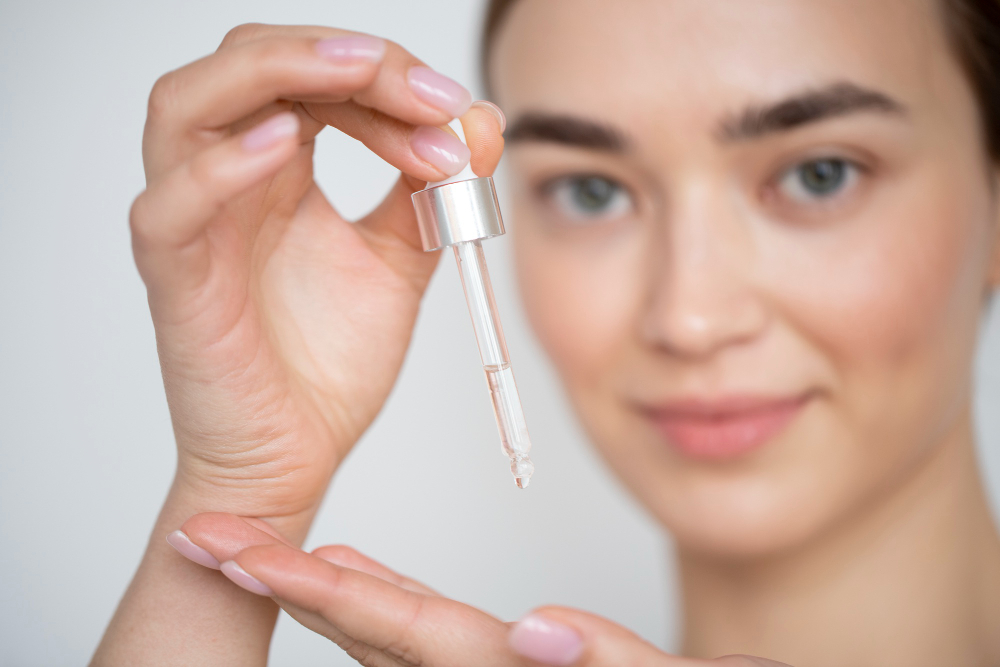 Kobieta trzyma pipetę z serum nad dłonią -co najlepiej nawilza skórę