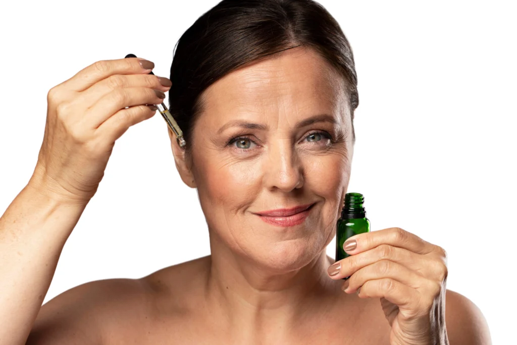 Uśmiechnięta kobieta dojrzała nakładająca serum